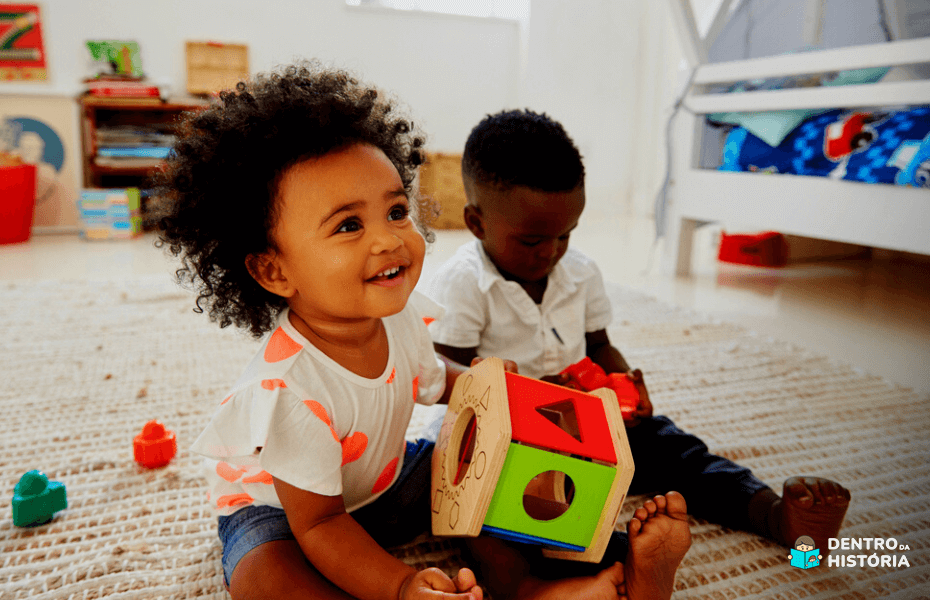 irmãos brincando com brinquedos de bebê