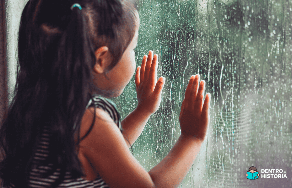 Criança olhando a chuva pela janela