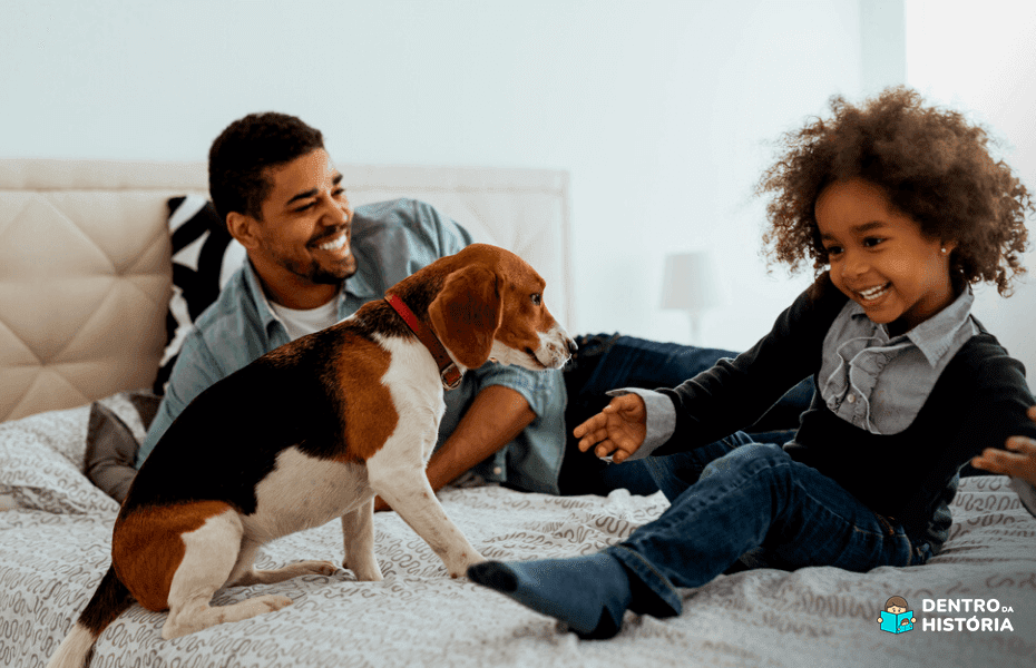 Pai e filha se divertindo com cachorro enquanto escolhem entre os nomes para pets